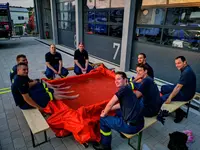 Helfer, die sich an einem Becken aus Leiterteilen die Füße kühlen